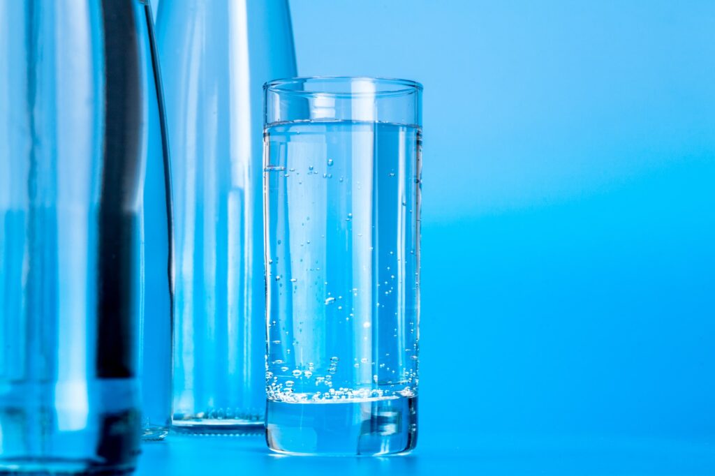 Glass water bottles on a light blue background