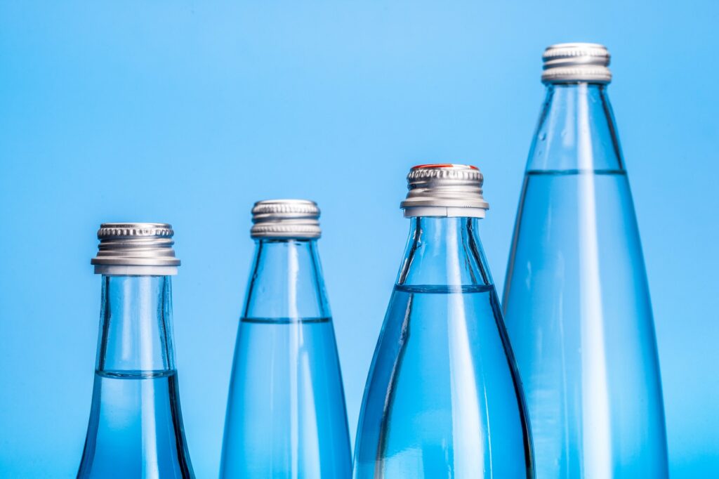 Glass water bottles on a light blue background