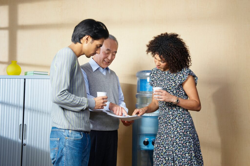 Office workers standing by water cooler