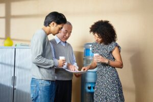 Office workers standing by water cooler