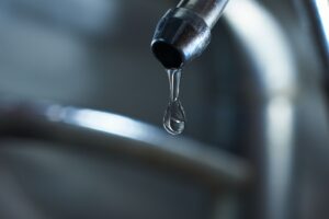 Reverse osmosis filter tap closeup with dripping water-drop.