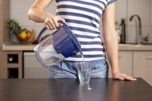 Woman pouring filtered water into a glass