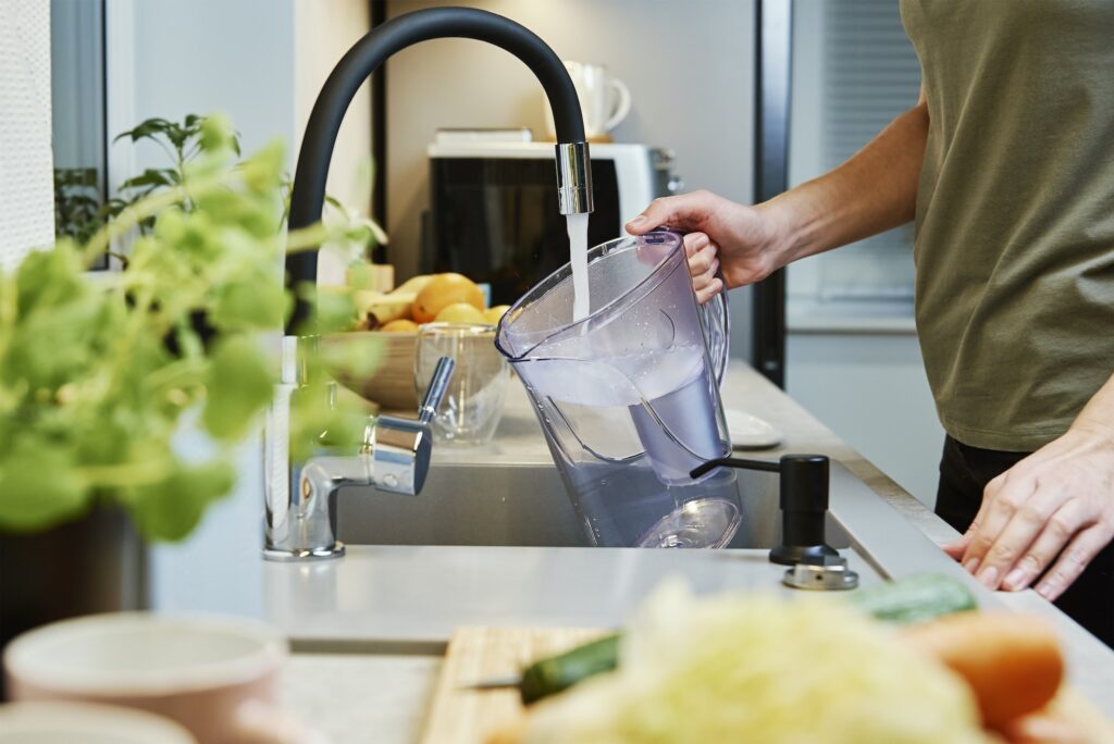 Woman pouring water filter jag