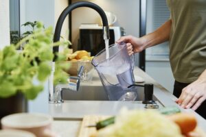 Woman pouring water filter jag