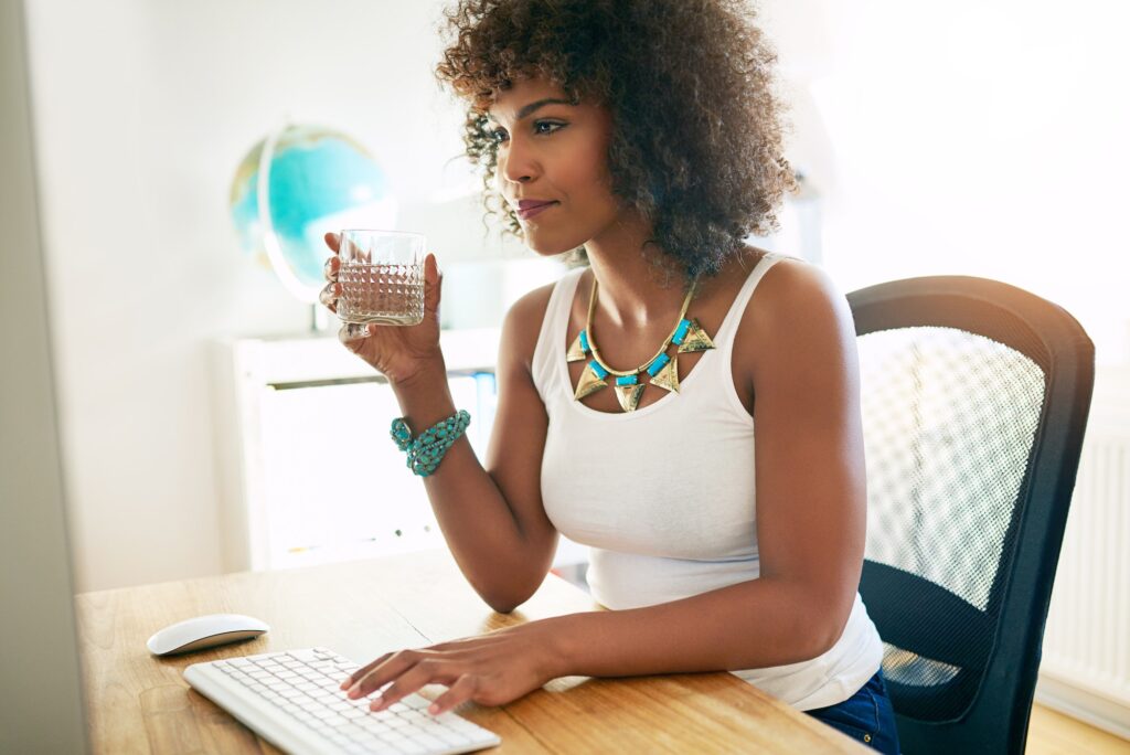 Young businesswoman drinking water